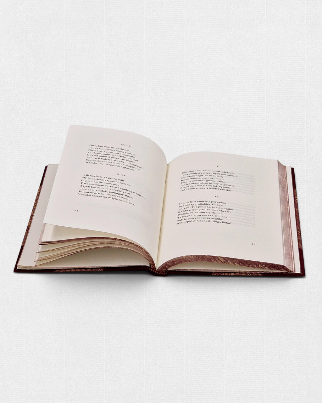 Otwarta książka „Wielki Testament” François Villona z widocznym układem wierszy, na papierze bawełnianym, w ręcznej oprawie z marmurkowanymi krawędziami bloku.