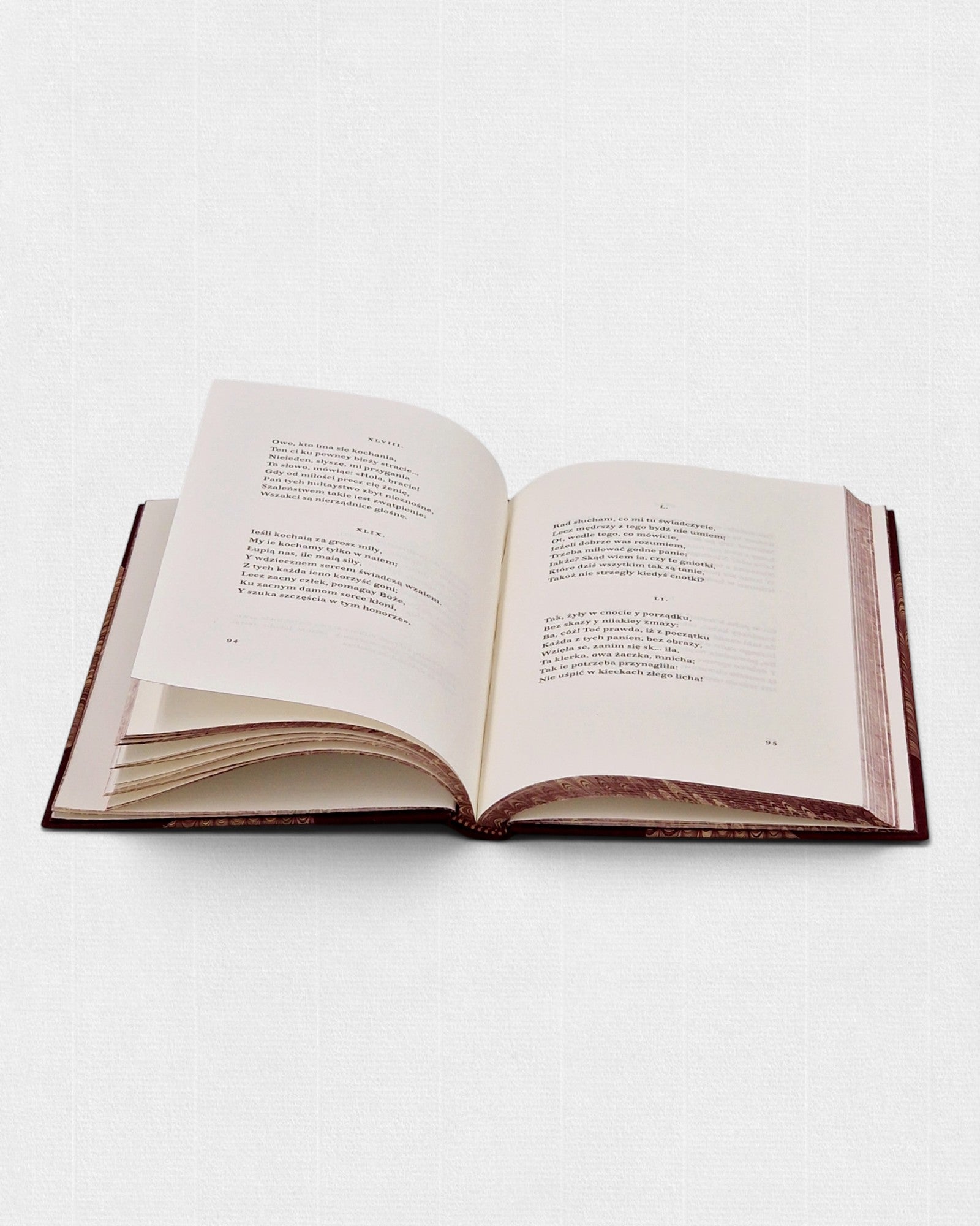 Otwarta książka „Wielki Testament” François Villona z widocznym układem wierszy, na papierze bawełnianym, w ręcznej oprawie z marmurkowanymi krawędziami bloku.